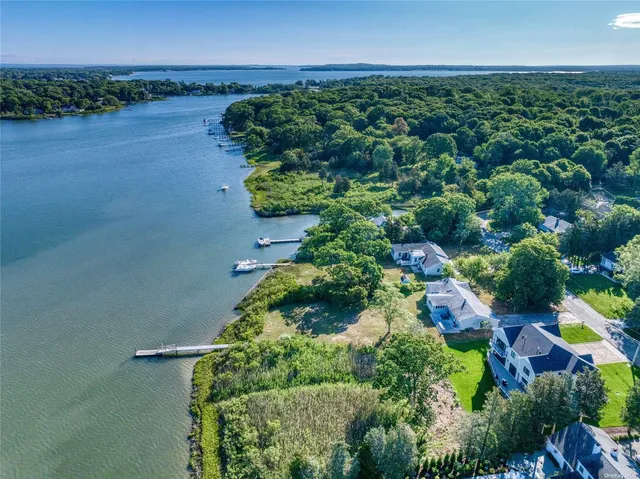 an aerial view of a house with a yard and lake view