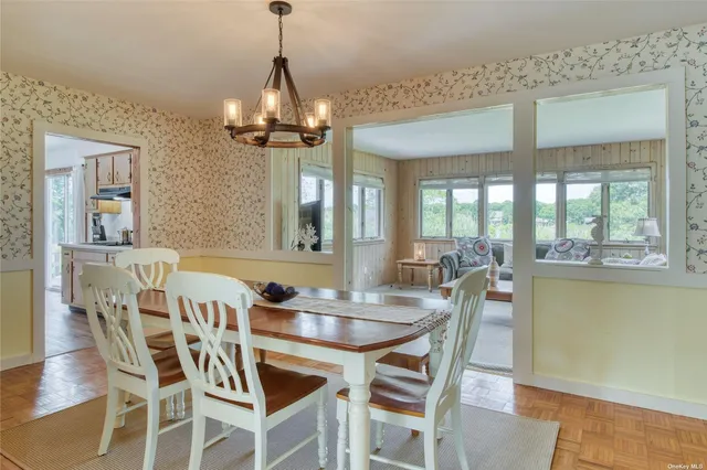 a dining room with furniture a chandelier and wooden floor