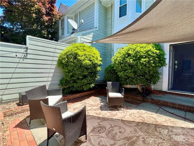 a view of a patio with a table and chairs and potted plants