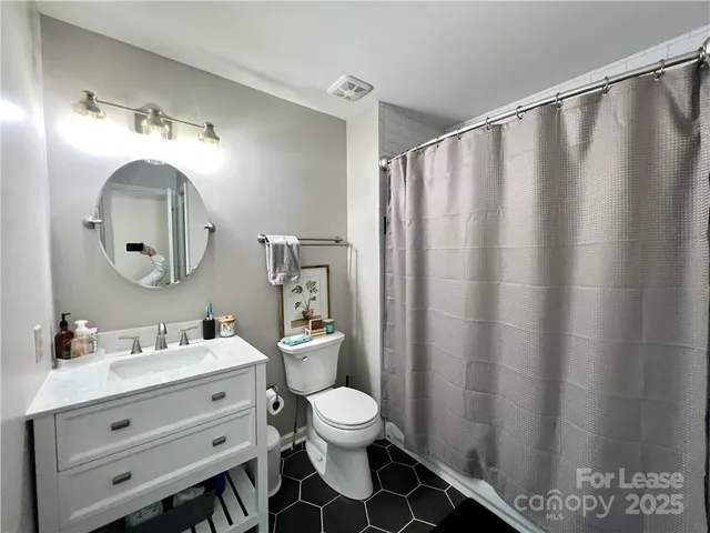 a bathroom with a double vanity sink toilet and a mirror