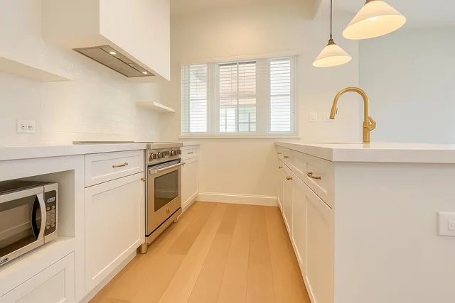 a kitchen with granite countertop white cabinets and white appliances
