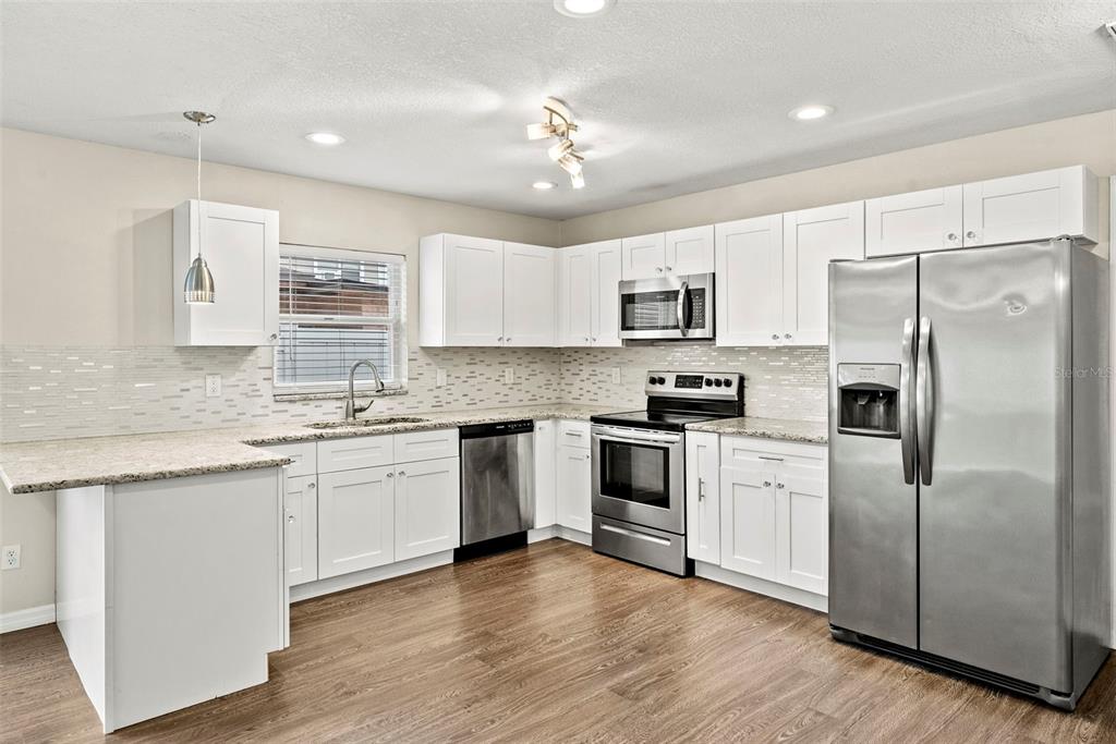 6601 North Elizabeth Street Tampa, FL 33604 - Photo 11 of 35 a kitchen with kitchen island granite countertop a sink cabinets and stainless steel appliances