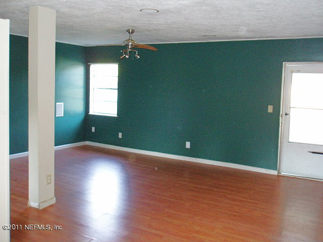 6876 Camelot Road Jacksonville, FL 32211 - Photo 4 of 11 an empty room with wooden floor and windows