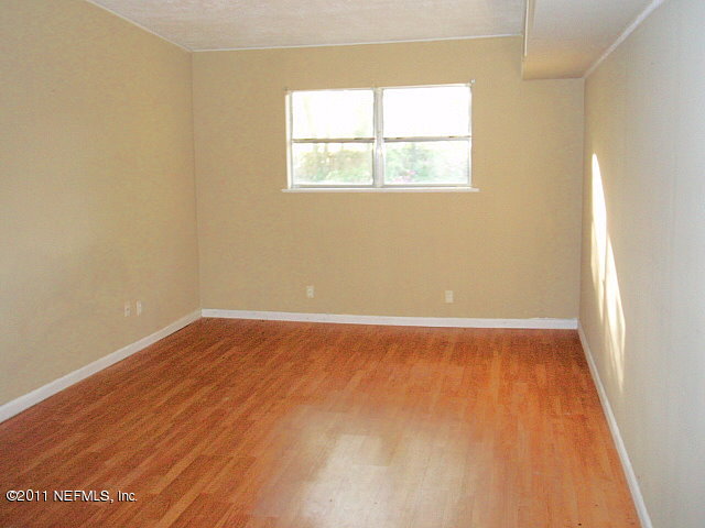 6876 Camelot Road Jacksonville, FL 32211 - Photo 5 of 11 an empty room with wooden floor and windows