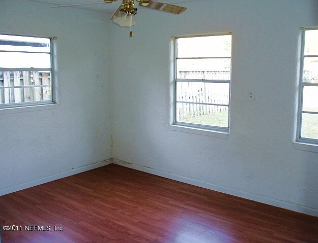 6876 Camelot Road Jacksonville, FL 32211 - Photo 7 of 11 an empty room with wooden floor and windows