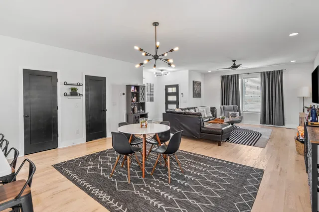 a living room with furniture a chandelier and a rug