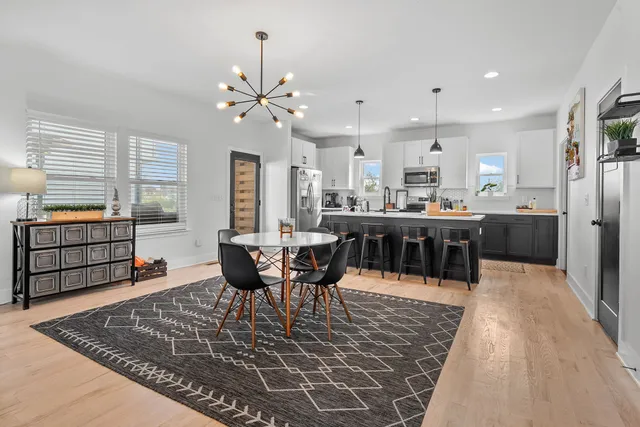 a living room with stainless steel appliances kitchen island granite countertop furniture wooden floor and a rug