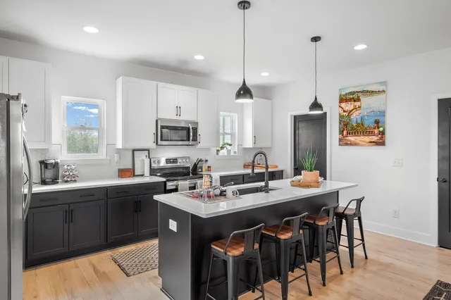 a kitchen with stainless steel appliances granite countertop a sink a stove a refrigerator and island