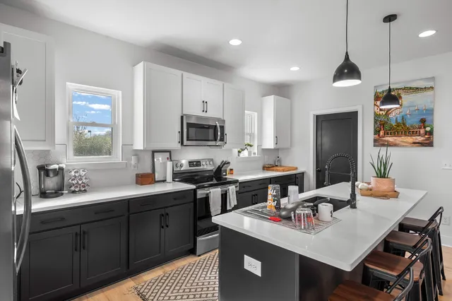 a kitchen that has a sink cabinets counter space and a window