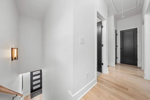 a view of a hallway with wooden floor and cabinet
