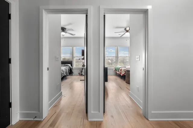 a view of a hallway with bathroom and wooden floor