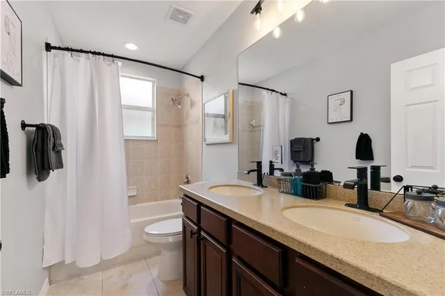a bathroom with a granite countertop sink toilet and mirror