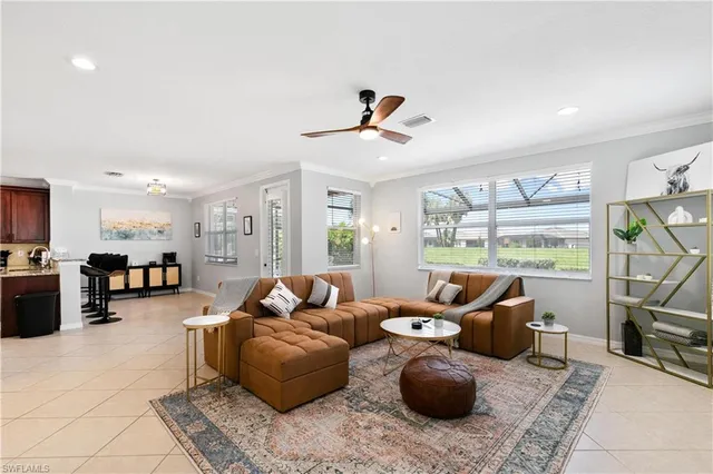 a living room with furniture a flat screen tv and a large window