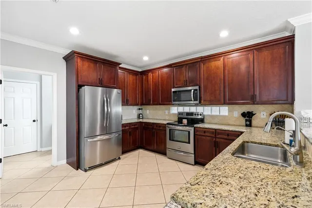 a kitchen with stainless steel appliances granite countertop a refrigerator sink and stove