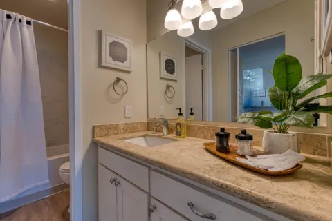 a bathroom with a granite countertop sink and a mirror