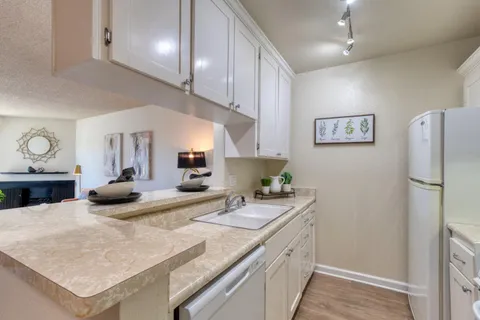 a kitchen with a sink a refrigerator and cabinets