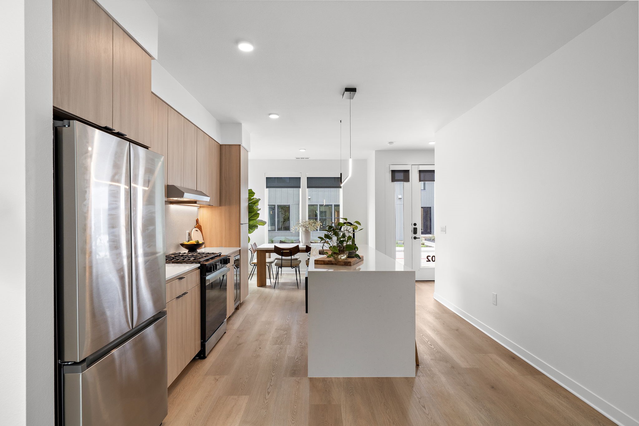 1941 Sawdust Road, Unit 120 The Woodlands, TX 77380 - Photo 11 of 38 a kitchen with stainless steel appliances a refrigerator a stove a sink a dining table and chairs with wooden floor