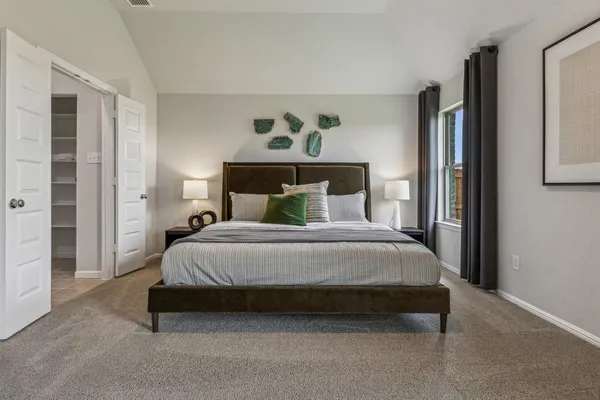 a bedroom with a bed large mirror and a window
