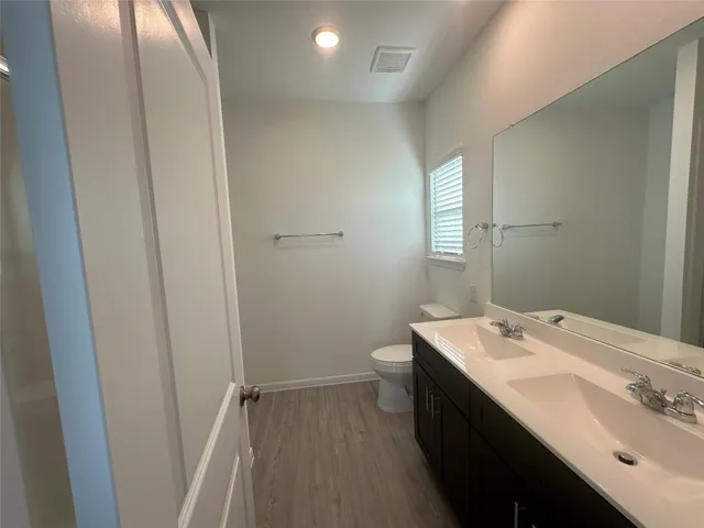 a bathroom with a sink a toilet and a mirror