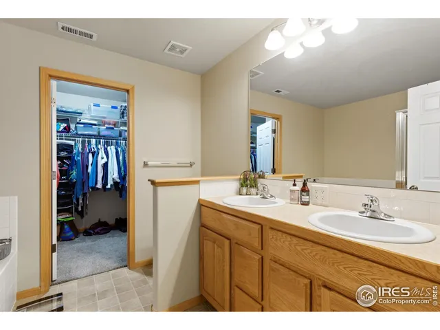 a en suite bathroom with a sink double vanity granite and a mirror