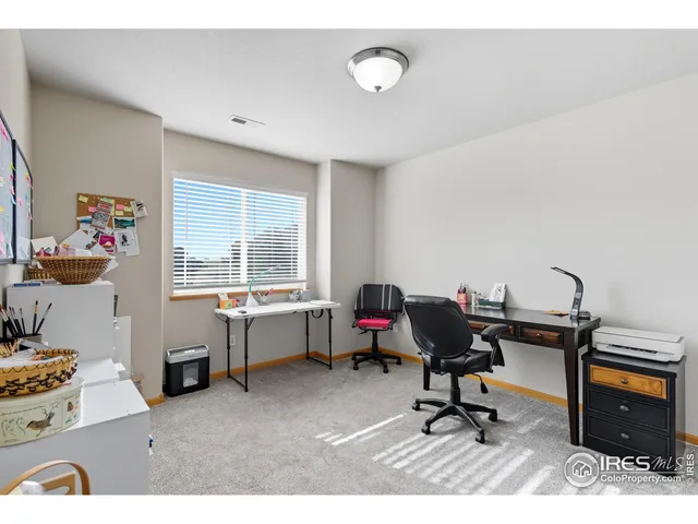 a view of a workspace with furniture and a window