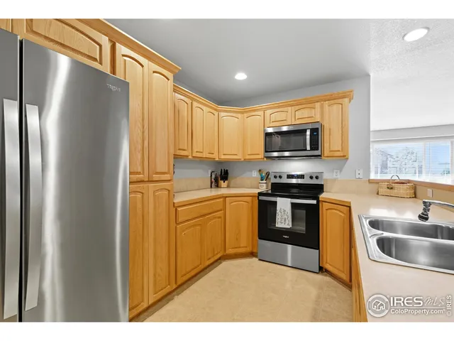 a kitchen with stainless steel appliances granite countertop a refrigerator a stove top oven a sink and dishwasher