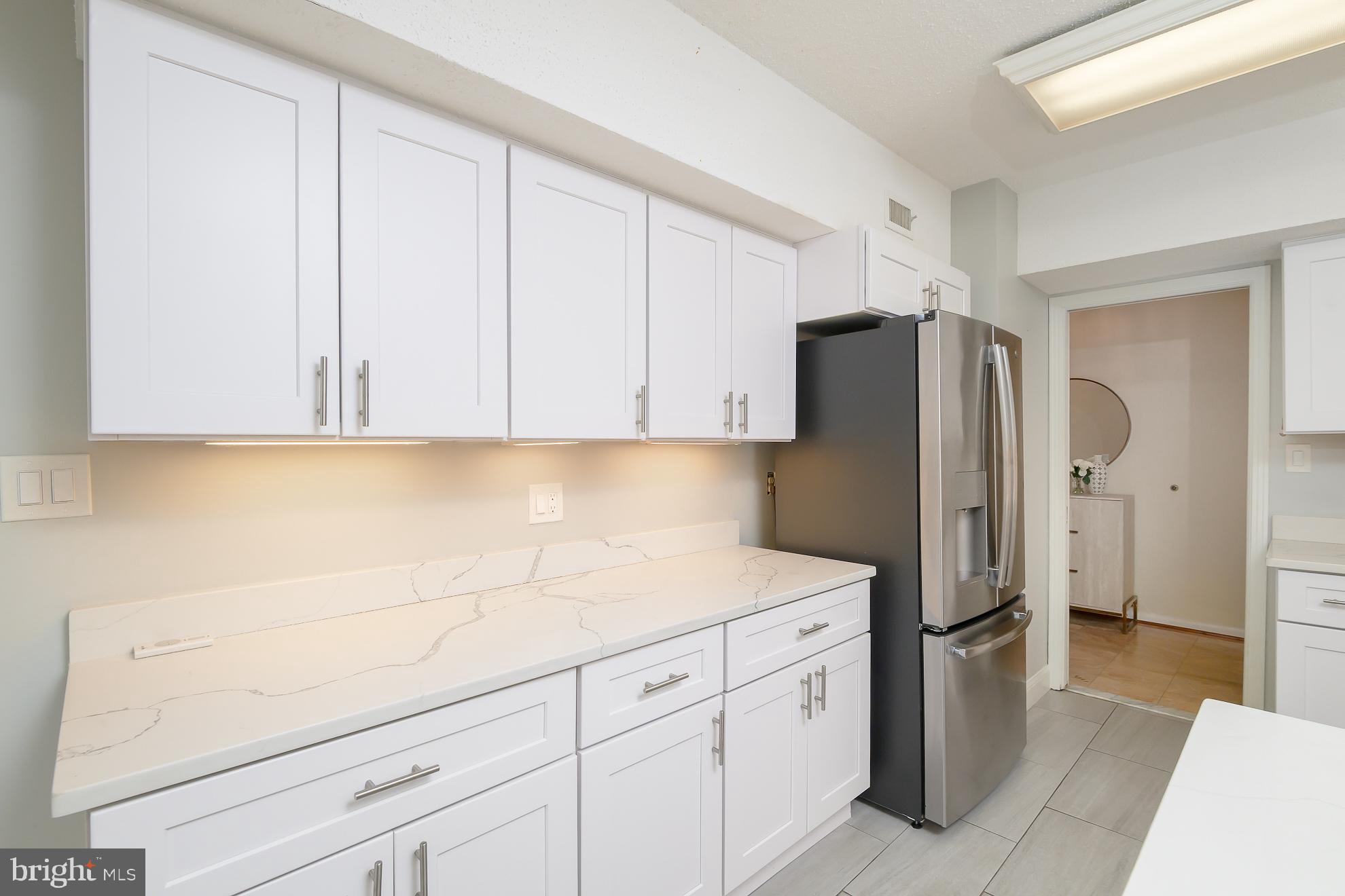 1016 South Wayne Street, Unit 604 Arlington, VA 22204 - Photo 16 of 42 a kitchen with stainless steel appliances white cabinets and refrigerator