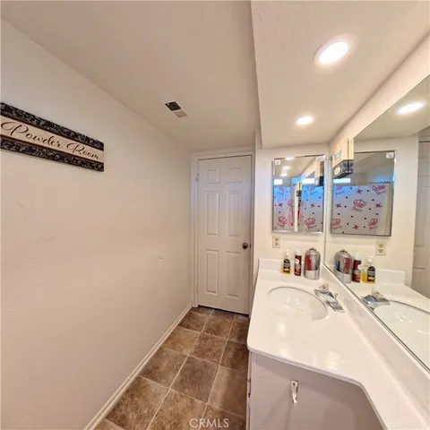 a room with a white bed and a dresser next to a window