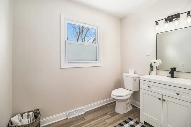 a bathroom with a toilet a sink and mirror