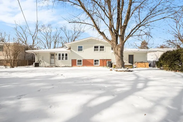 a view of white house with a yard covered in snow
