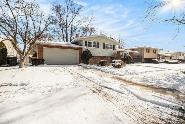 a front view of a house with a yard covered in snow
