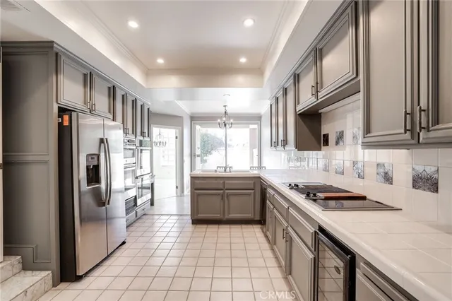 a kitchen with stainless steel appliances a refrigerator a sink and wooden cabinets