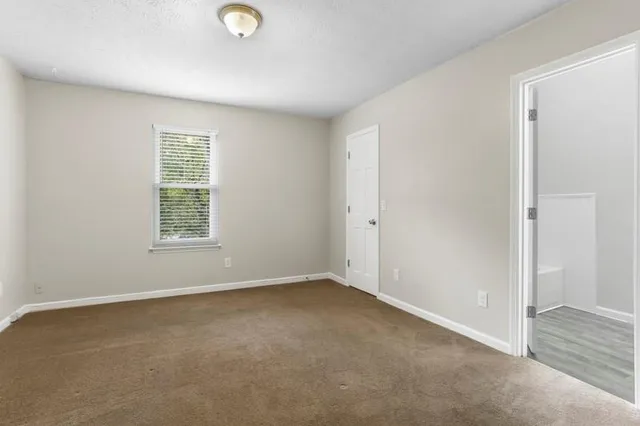 an empty room with windows and closet