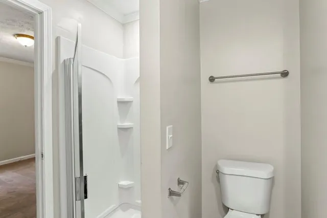a bathroom with a toilet and a shower