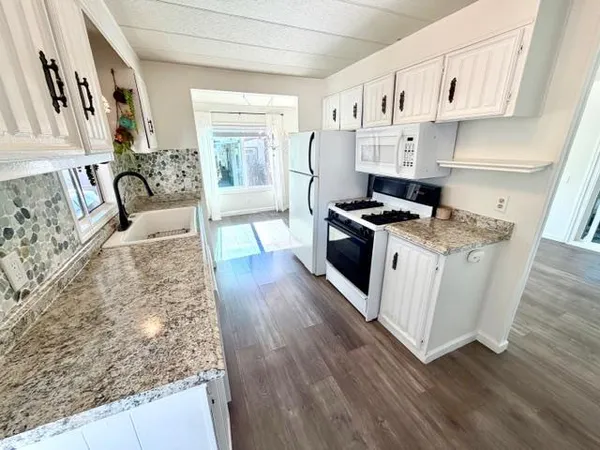 a kitchen with stainless steel appliances granite countertop a stove a sink and a refrigerator