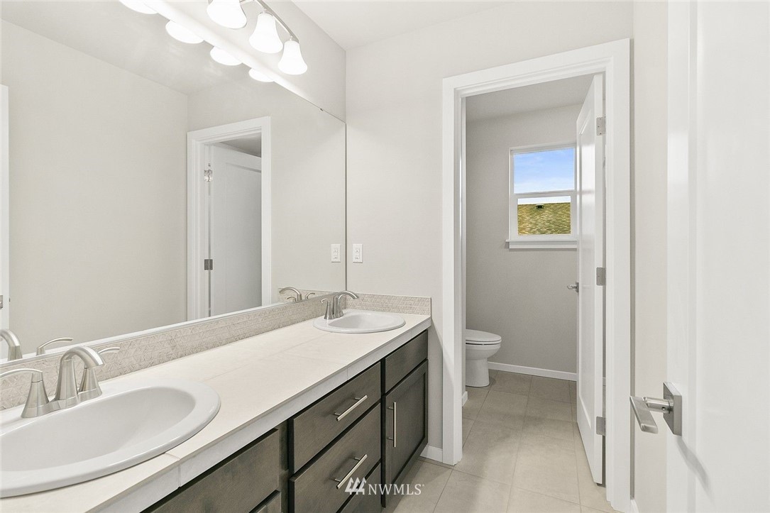 26832 102nd Place Southeast Kent, WA 98030 - Photo 19 of 31 a bathroom with a granite countertop sink a toilet and a mirror