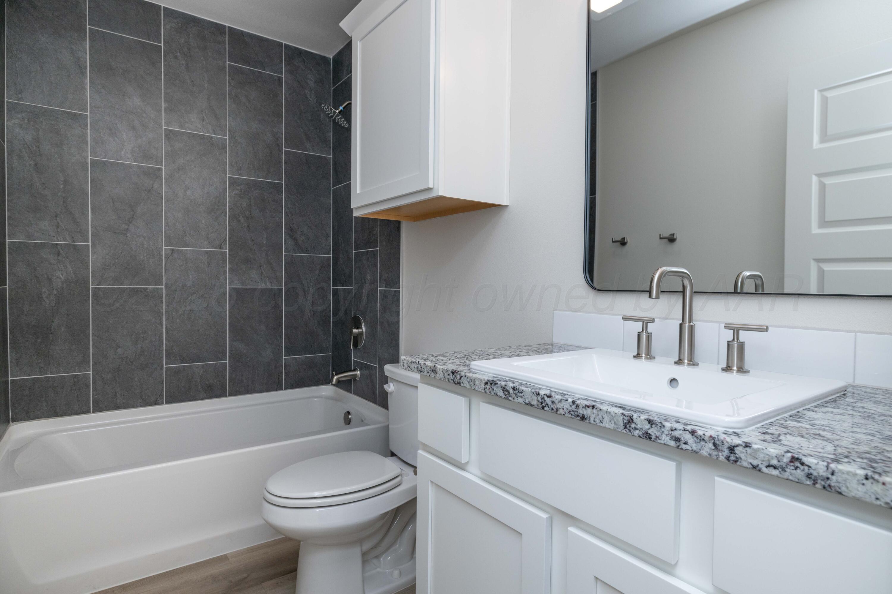 3006 Frontier Lane Amarillo, TX 79124 - Photo 12 of 16 a bathroom with a granite countertop sink a toilet and bathtub