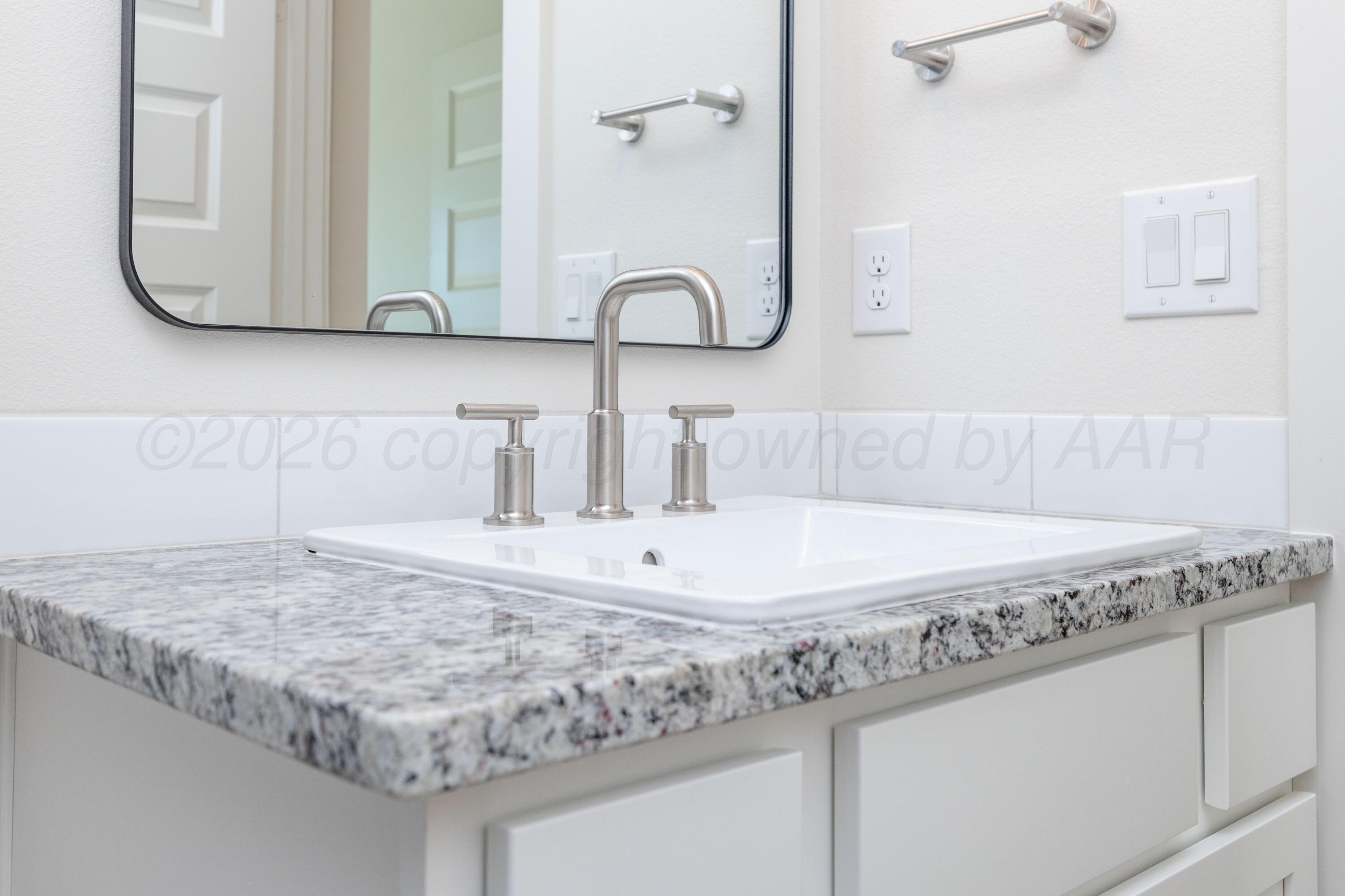 3006 Frontier Lane Amarillo, TX 79124 - Photo 13 of 16 a bathroom with a granite countertop sink and a mirror
