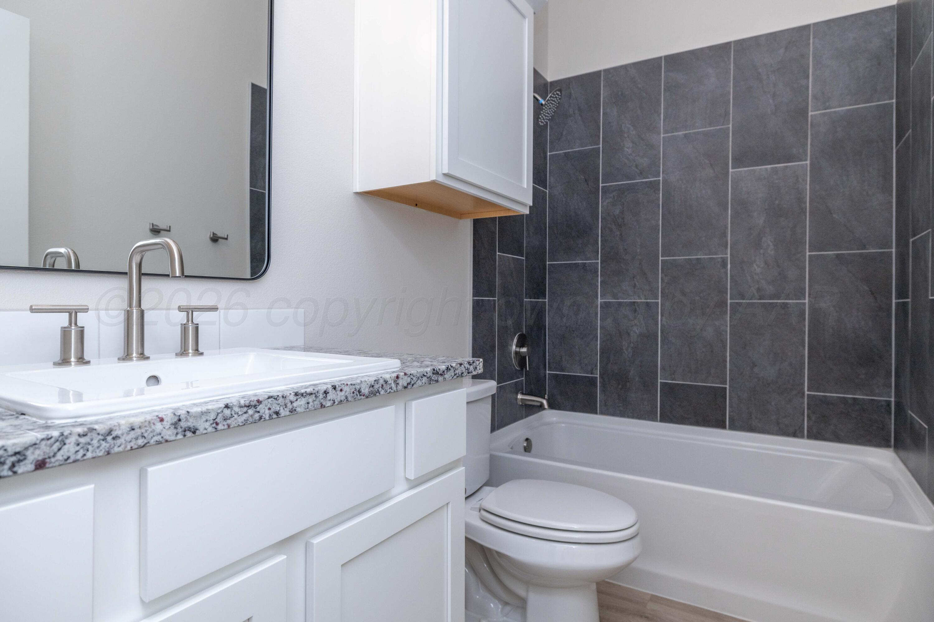 3006 Frontier Lane Amarillo, TX 79124 - Photo 14 of 16 a bathroom with a granite countertop sink a toilet and bathtub