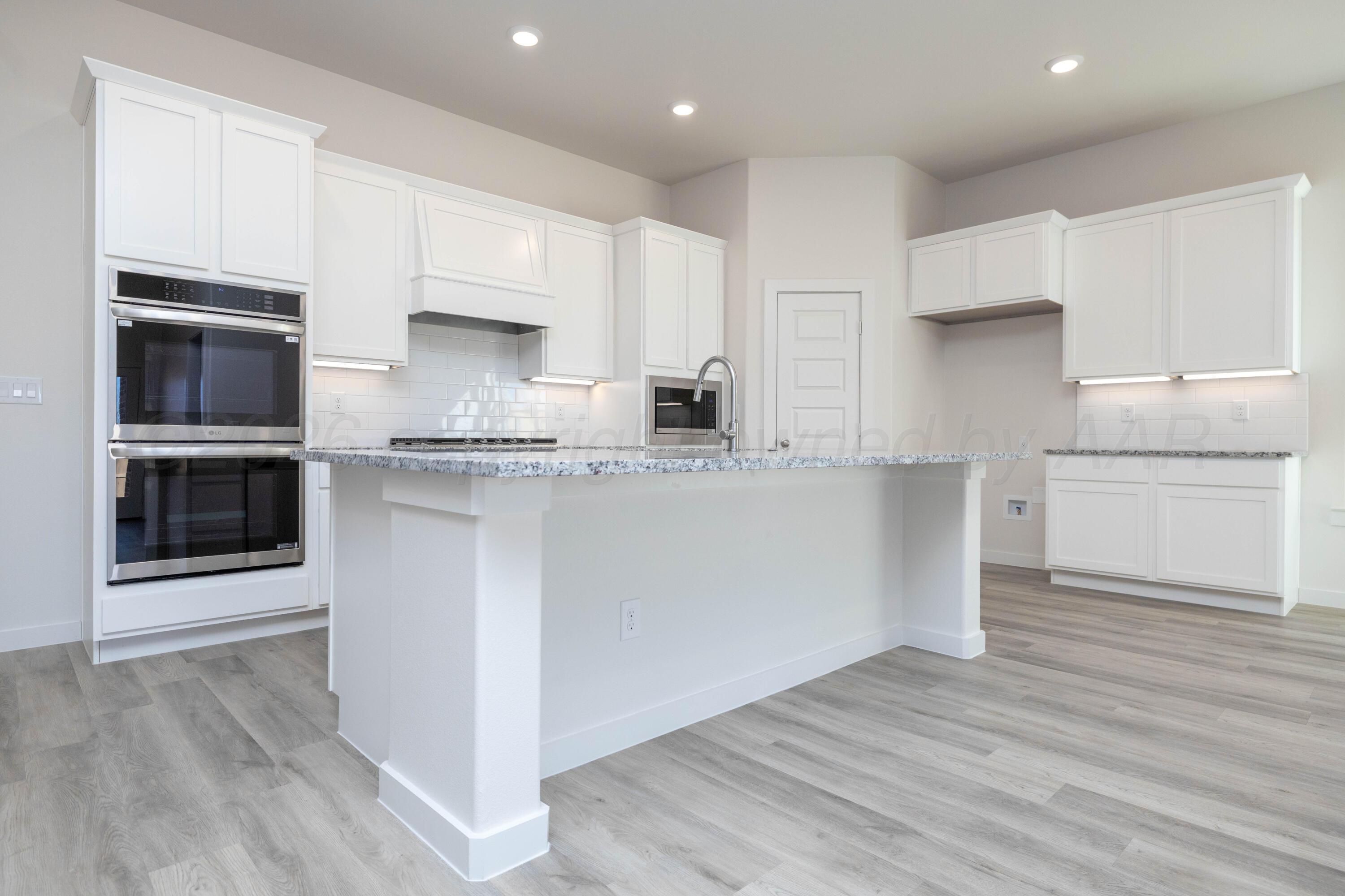3006 Frontier Lane Amarillo, TX 79124 - Photo 2 of 16 a kitchen with stainless steel appliances granite countertop a stove a sink and a microwave