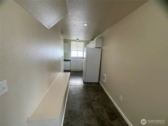 a kitchen with refrigerator and white cabinets