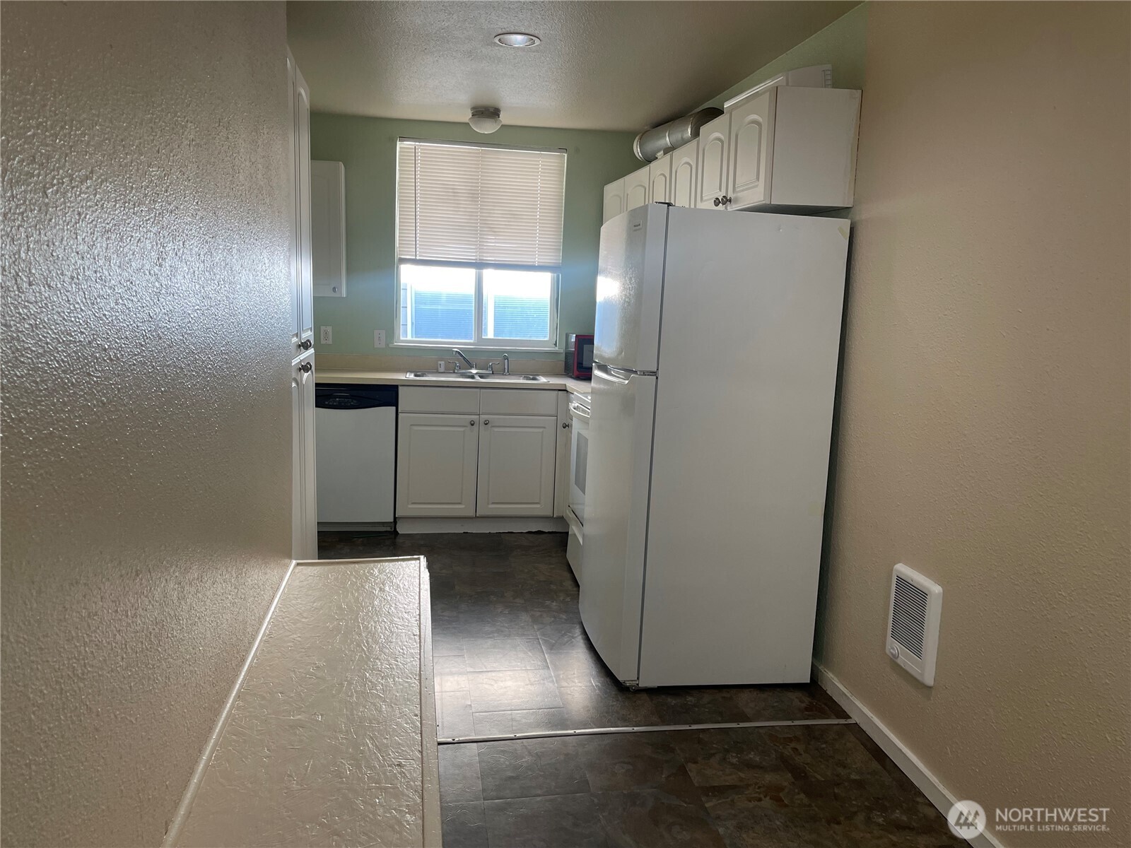 220 West 4th Street Aberdeen, WA 98520 - Photo 18 of 26 a kitchen with refrigerator and white cabinets