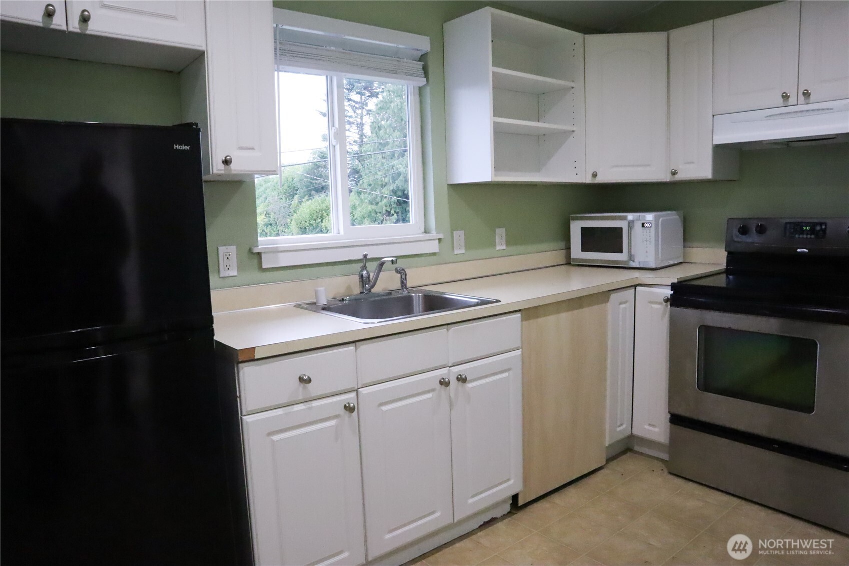 220 West 4th Street Aberdeen, WA 98520 - Photo 10 of 26 a kitchen with granite countertop white cabinets and black appliances