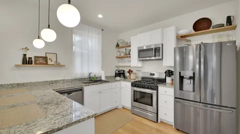 a kitchen with stainless steel appliances granite countertop a refrigerator sink and stove