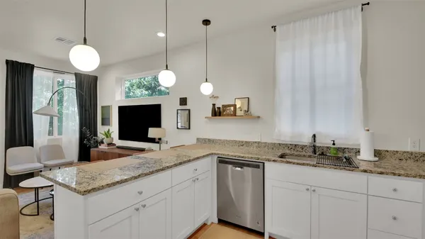 a kitchen with a sink and a flat screen tv