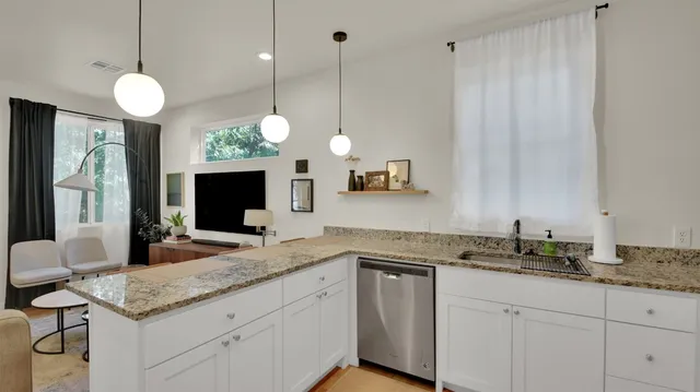 a kitchen with a sink and a flat screen tv