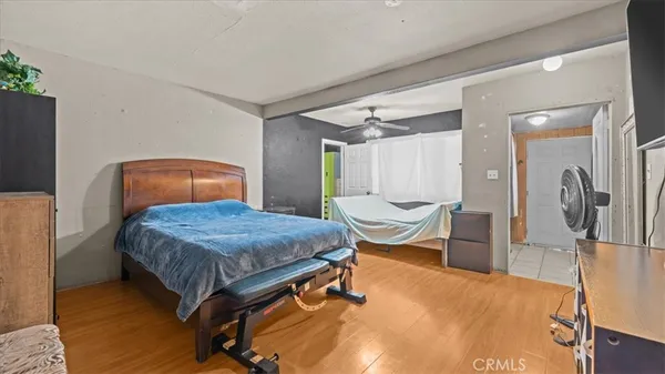 a bedroom with a bed a table and wooden floor