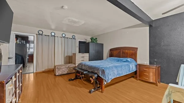 a kitchen with stainless steel appliances kitchen island granite countertop a refrigerator a stove and a sink with wooden floor