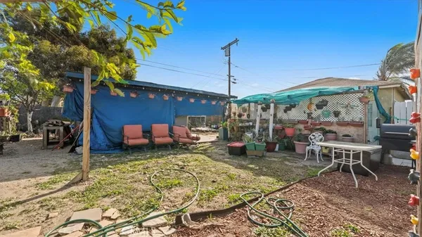 a view of a patio with table and chairs potted plants and a palm tree