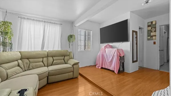 a living room with a bed furniture and a flat screen tv